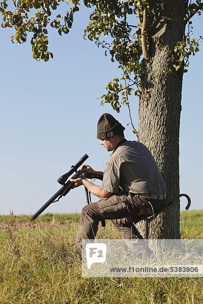 Hunter on a driven hunt  reloading his rifle