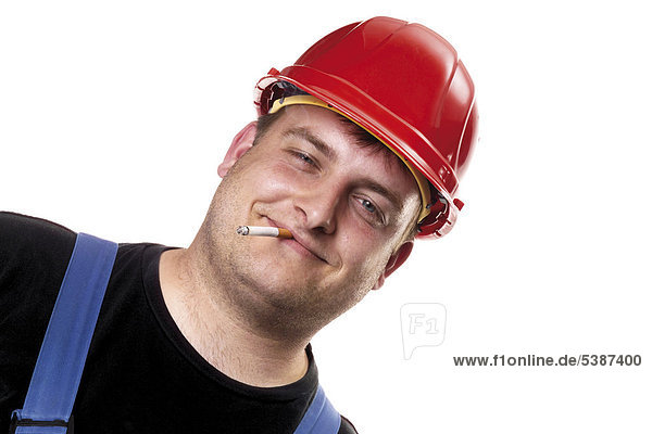 Handwerker mit rotem Bauhelm raucht eine Zigarette