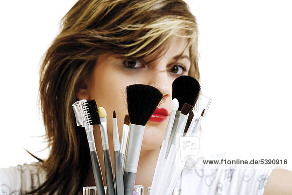 Junge Frau mit Makeup-Pinseln