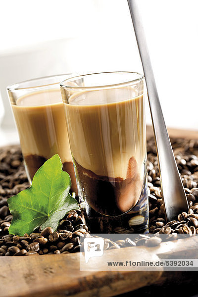 Latte Macchiato-Likör auf Schokolikör in einem Bett aus Kaffeebohnen