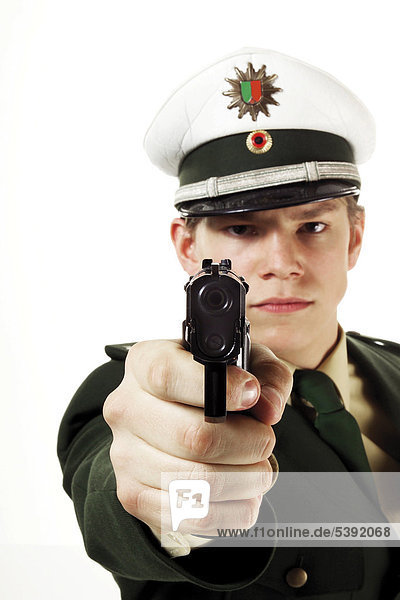 Junger Polizist zielt mit Pistole