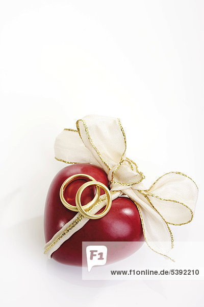 Rotes Herz mit Schleife mit Eheringen ( Symbol Hochzeit - Verlobung )
