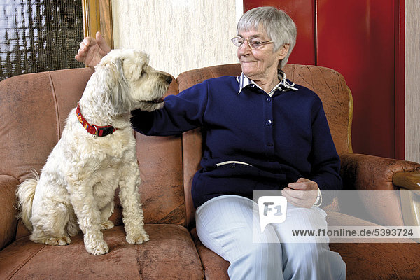 Im Pflegeheim  Altenheim  Seniorin streichelt einen Hund
