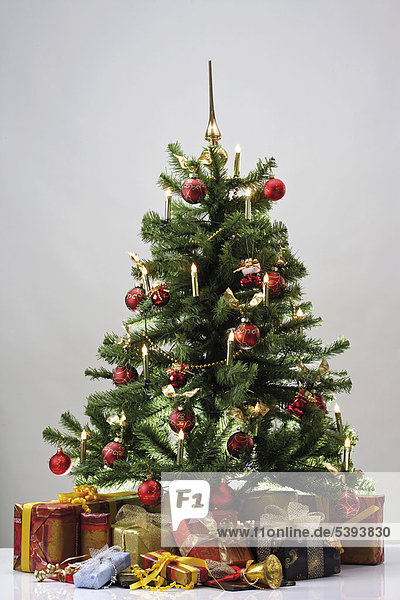 Decorated Christmas tree (artificial) surrounded by wrapped presents