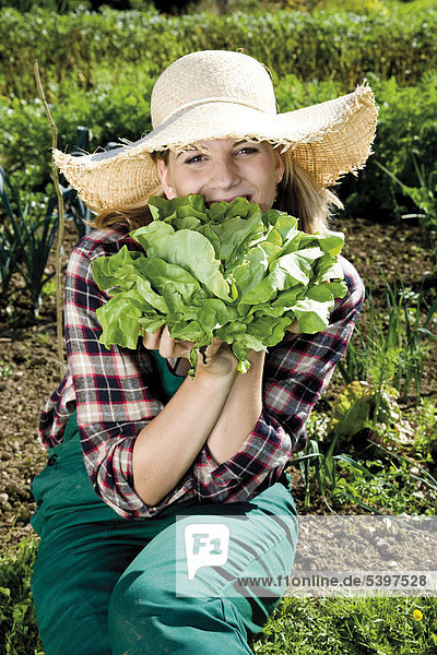 Young female gardener with lettuce