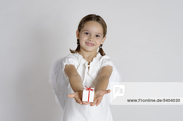 Girl dressed up as a Christmas angel with a gift  Christmas