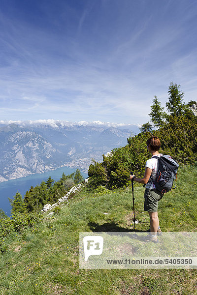 Hiker climbing Mt Monte Altissimo above Nago-Torbole  Lake Garda and Arco below  Trentino  Italy  Europe