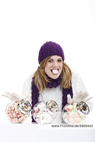 Young woman behind sweet jars filled with marshmallows