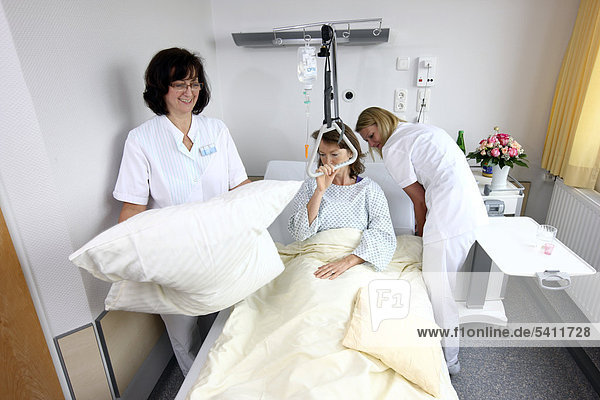 Patientin im Krankenbett  Krankenschwestern machen das Bett  Einzelzimmer  Krankenhaus