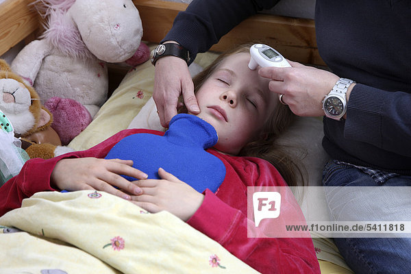 Mädchen  10 Jahre  liegt krank im Bett  mit Grippe  Erkältung  Schnupfen  Mutter misst Fieber mit einem digitalen Hautthermometer