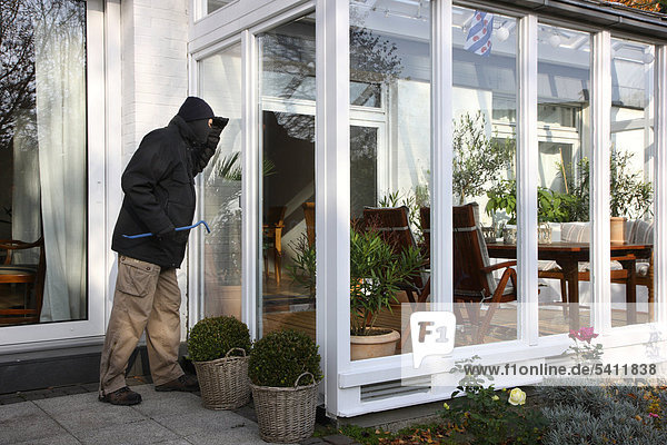 Burglar planning burglary  spying out a house  symbolic image for domestic burglary