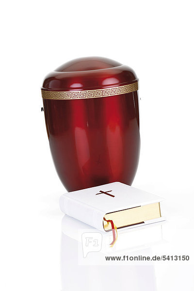 Bible placed in front of a red urn