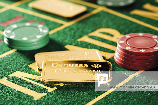 Gold bars on roulette table with casino chips