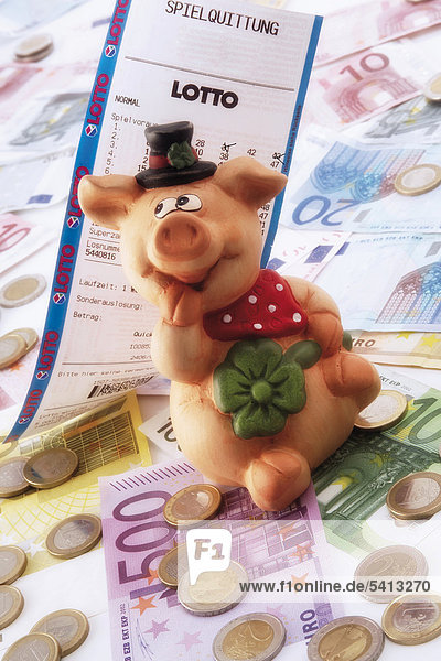 Glücksschwein mit Lottoschein auf Euroscheinen