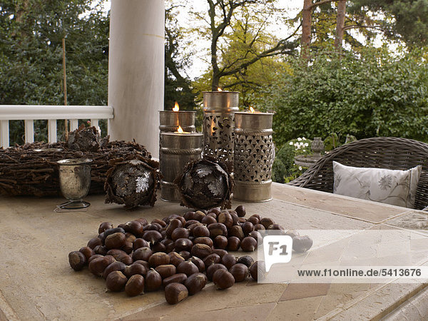 Autumnal atmosphere with chestnuts and candles on an outdoor terrace