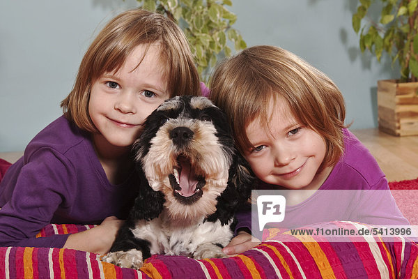 Mädchen  Zwillinge  sechs Jahre  mit Mischlingshund