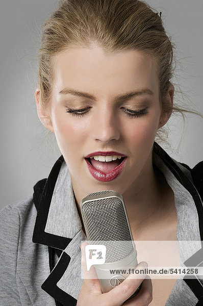 Junge Frau mit professionellem Broadcast-Mikrofon mund