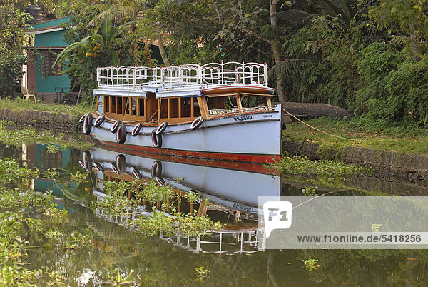 Ein Boot spiegelt sich in den Backwaters nahe Kumarakom  Kerala  Indien  Asien