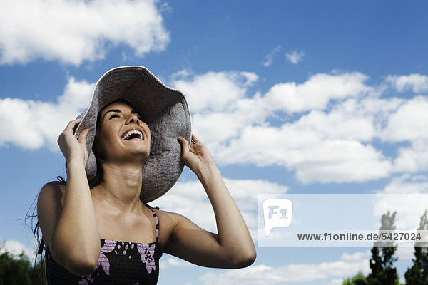 Young woman wearing sun hat  laughing