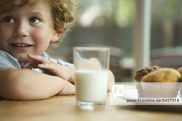 Little boy sitting at table with snack