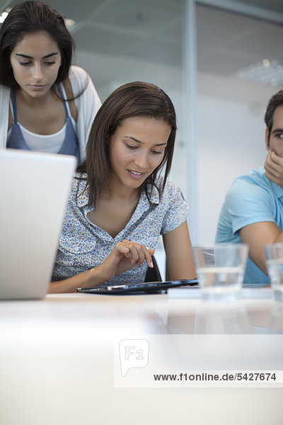 Woman using tablet computer while friends watch