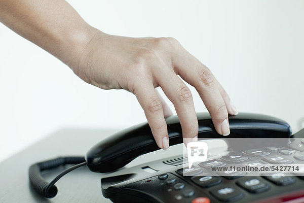 Hand picking up telephone receiver  cropped