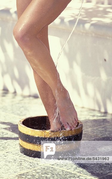 Frau wäscht sich die Füße in einem Zuber
