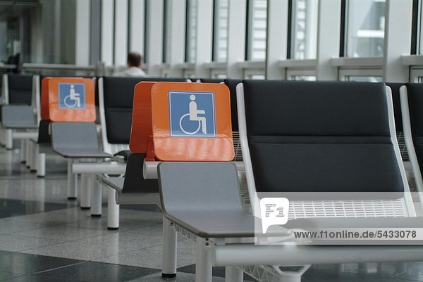 Sitzmöglichkeiten für Rollstuhlfahrer in einer Wartehalle auf dem Flughafen