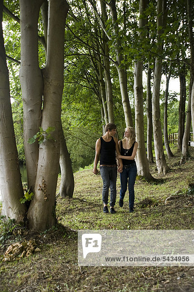 junges Paar geht verliebt im Wald spazieren