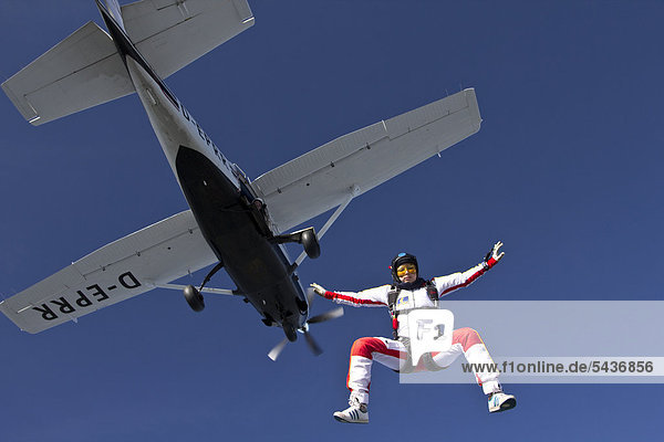 Fallschirmspringerin springt aus dem Flugzeug