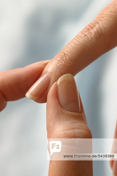 Nahdetail - zwei Finger massieren einen weiblichen Mittelfinger - Finger Akupressur - Mittelfinger : Element Erde - gegen Kopfschmerzen   Halsschmerzen   Muskelverspannungen   Magenprobleme   Schlafstörungen   Gewichtsregulierung