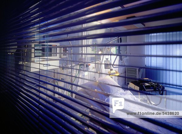 Blick durch eine Jalousie in ein Patientenzimmer auf einer Intensivstation in einer Heliosklinik.