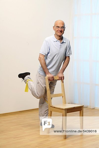 hinter stehend Senior Senioren Mann Stuhl heben Training Menschlicher Muskel Menschliche Muskeln Boden Fußboden Fußböden alt