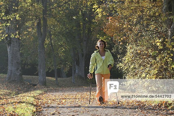 Young Woman Nordic Walking on a sunny autumn afternoon