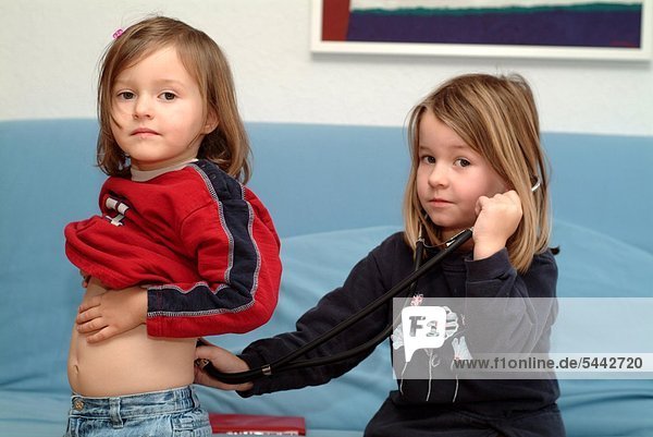 Zwei Mädchen (3 und 5 Jahre) untersuchen sich mit Stethoskop