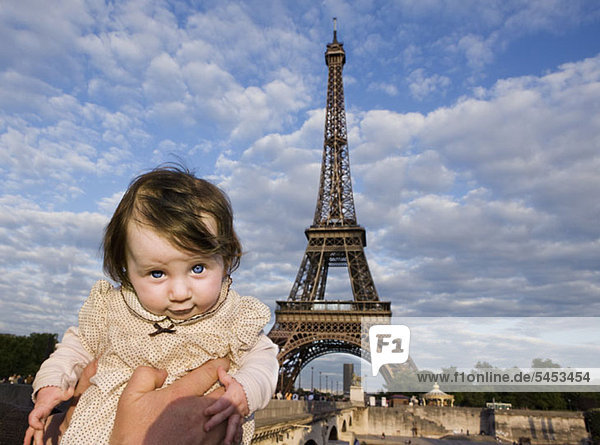 Ein Baby wird vor dem Eiffelturm gehalten  Paris  Frankreich
