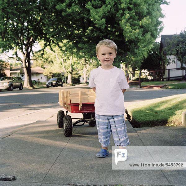 Ein Junge mit einem Spielzeugwagen  Portrait