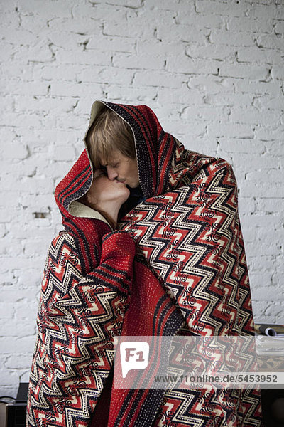 A couple kissing while wrapped in a blanket