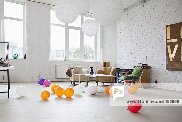 Mehrfarbige Luftballons auf dem Boden eines modernen Wohnzimmers