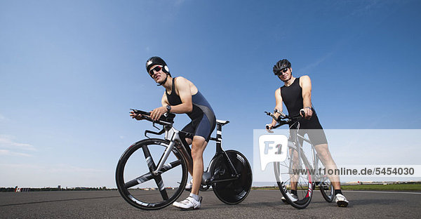 Two cyclists pausing on their racing bicycles