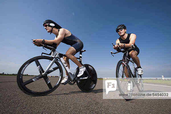 Zwei Radfahrer auf Rennrädern,  Seitenansicht,  Flachwinkelansicht