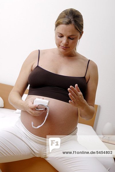 Schwangere Frau misst ihren Blutdruck