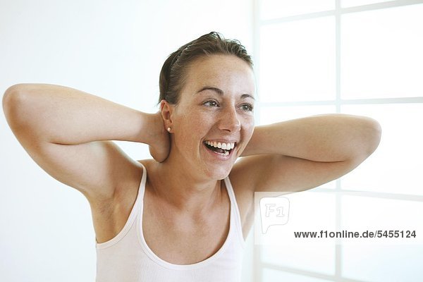 Young woman crosses hands behind head  laughing