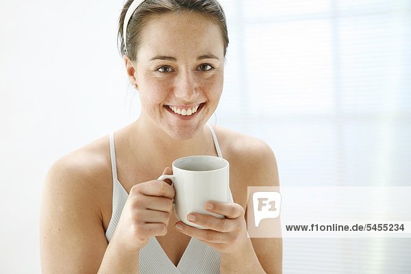 Smiling woman holding cup of tea