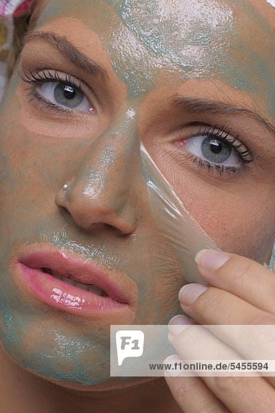 Junge Frau entfernt ihre Gesichtsmaske  Portrait