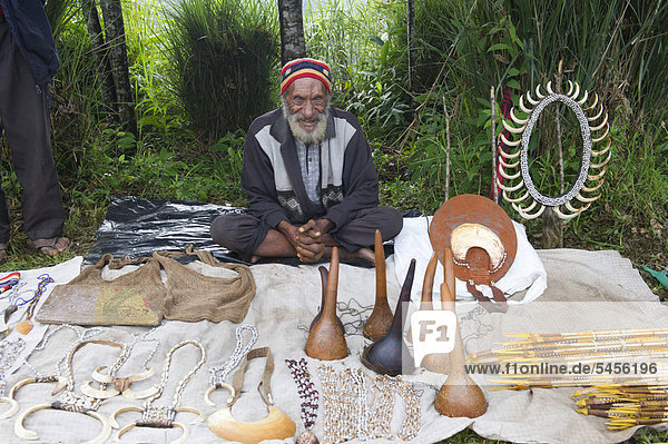 Mann verkauft Penisköcher aus Kalebassen  Stoßzähne von Schweinen und andere Gegenstände beim Paiya-Festival  Papua-Neuguinea  Ozeanien