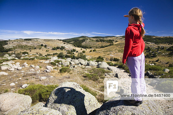 Girl stands on a rock overlooking the natural landscape in the Cevennes National Park  France  Europe