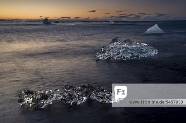 Small icebergs being washed from the sea to the black sand beach at dusk  Joekuls·rlÛn  South Iceland  Iceland  Europe