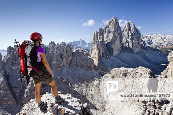 Kletterin beim Aufstieg zum Paternkofel  hinten die Drei Zinnen  Sexten  Hochpustertal  Dolomiten  Südtirol  Italien  Europa