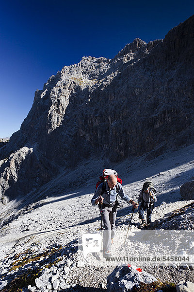 Hikers in Elferscharte during the ascent to the Alpinisteig fixed rope route across Fischleintal valley above Talschlusshuette mountain hut  Hochpustertal Valley  Sexten  Dolomites  South Tyrol  Italy  Europe